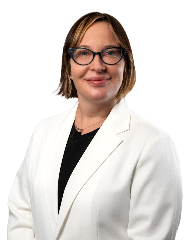 Professional headshot of Dr. Bonnie McKinley wearing a white lab coat, smiling at the camera against a black background. This is a standard medical professional portrait used for clinic or practice identification.